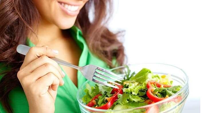pige, der spiser grøntsagssalat på en proteindiæt