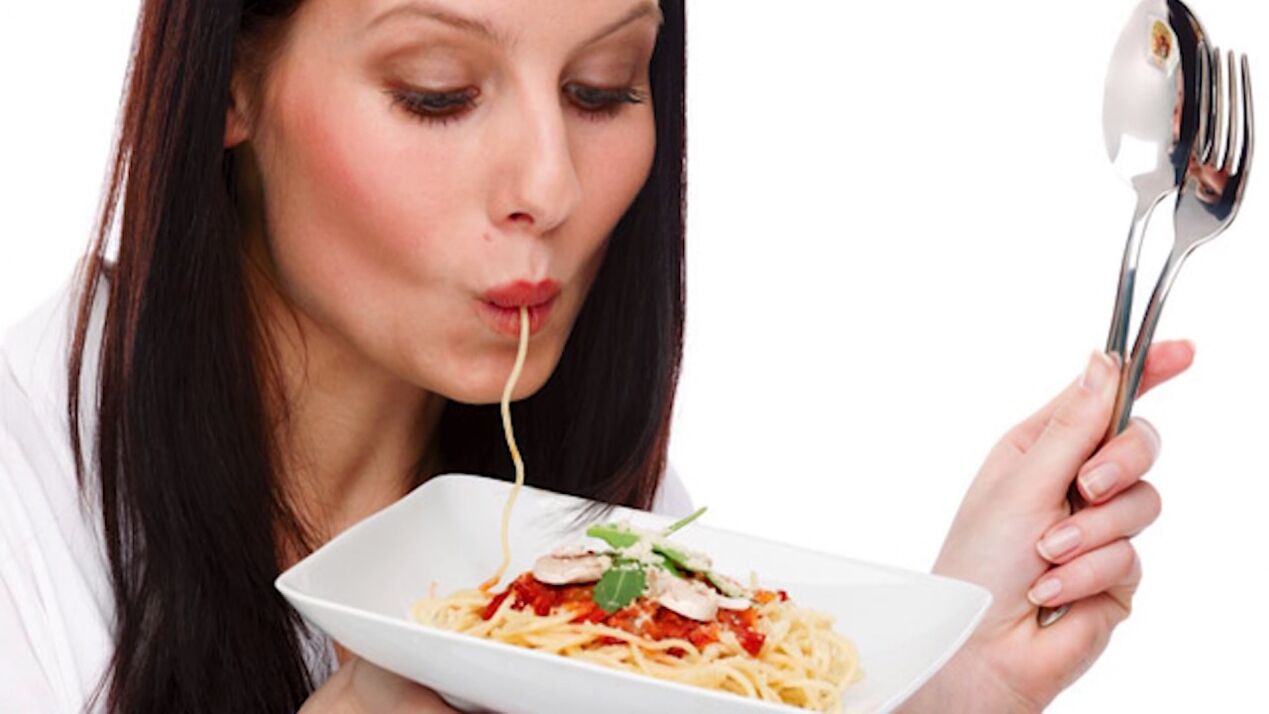 kvinde spiser spaghetti for at slanke maven